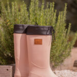 Vaaluanpunaiset kumisappaat, joidenka takana on pensas.